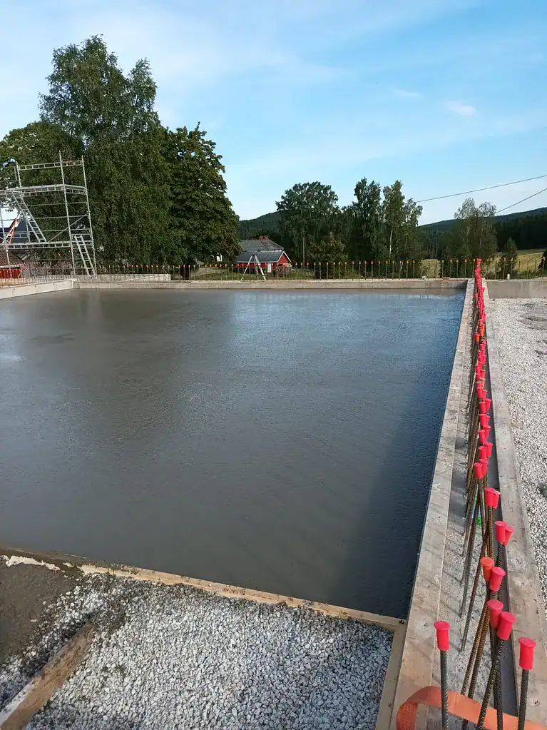 Robust betongpåfylling for vannreservoar med stålstøtte og sikkerhetsnett.